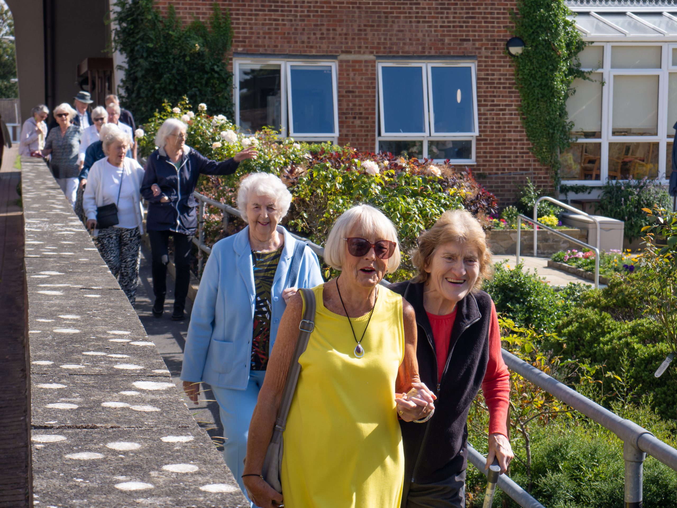 Residents smiling as they walk along a path